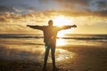Worship, sunrise and silhouette of man at the beach standing with arms raised. Faith, religious and spiritual person Royalty Free Stock Photo