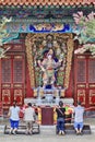 Worshippers in front of an ornate altar at Yuantong Temple, Kunming, China