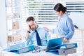 Frustrated young man sitting while his kind colleague touching his shoulder Royalty Free Stock Photo