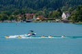 WORTHERSEE, AUSTRIA - AUGUST 08, 2018: Happy young people, on inflatable attractions, drive behind a motorboat on the lake