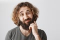 It would be problematic. Portrait of hesitating unsure eastern man scratching beard and lifting eyebrows with doubtful Royalty Free Stock Photo