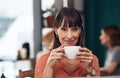 Would you like some coffee too. Portrait of an attractive middle aged woman having a cup of coffee inside of a coffee Royalty Free Stock Photo