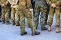 A wounded soldier of the Ukrainian army stands with a crutch near the formation of war veterans, Defender Ukraine Day Royalty Free Stock Photo