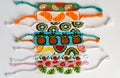 Woven DIY friendship bracelets handmade of embroidery bright thread with knots isolated on white background. Fruit alpha patterns Royalty Free Stock Photo