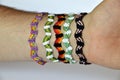 Woven friendship bracelets handmade of thread on males wrist.