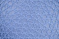 Woven mesh of artificial material on blue background