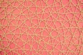 woven mesh of artificial material on a pink background