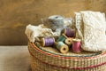 Woven rattan crafts and sewing supply box, wooden spools, rolls of lace, aged wood background, hobby clothing concept Royalty Free Stock Photo