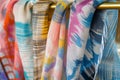 woven scarves with abstract spring patterns on a brass rack