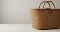 A woven straw handbag sits on a light-colored surface against a plain background. Th Royalty Free Stock Photo