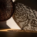 A woven wicker basket casts intricate shadows on a textured white wall. The basket Royalty Free Stock Photo