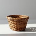 A woven wicker basket is displayed on a smooth, white surface. The basket features Royalty Free Stock Photo