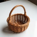 Woven wicker basket with a sturdy handle, resting on a smooth, white surface. The Royalty Free Stock Photo