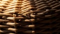 Close up view of tightly woven natural wicker texture illuminated by warm sunlight creating deep shadows and contrast Royalty Free Stock Photo