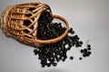 Woven wooden basket with a black large berry
