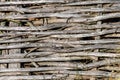 Woven wooden fence made of thin old branches in the countryside. village yard fence from wood close-up Royalty Free Stock Photo