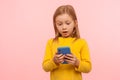 Wow, amazing app for kids. Portrait of astonished little girl using smartphone with shocked expression Royalty Free Stock Photo