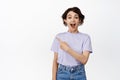 Wow awesome sale ahead. Smiling excited brunette girl pointing finger left, looking in awe, amazed face, recommend take Royalty Free Stock Photo