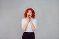 Wow. Close up portrait young woman beautiful girl with curly red hair looking excited holding her mouth opened, hands on cheeks, Royalty Free Stock Photo