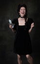 Creative portrait of young excited woman in image of medieval royal person in black dress isolated on dark vintage