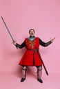 One young man, medieval warrior or knight wearing wearing armor clothing posing isolated over pink background Royalty Free Stock Photo