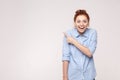 Wow! Handsome redhead woman in shoked. Pointing away while stand Royalty Free Stock Photo