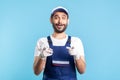 Wow hey you! Amazed crazy handyman in overalls pointing to camera and looking surprised. Profession of service industry Royalty Free Stock Photo