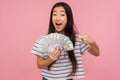 Wow, I`m rich. Portrait of shocked surprised girl with brunette hair pointing at dollar bills with amazed look