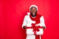 Wow its for me. Portrait of excited african man in santa claus cap hold big package get present for newyear celebration Royalty Free Stock Photo