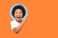 Wow look, advertise here! Portrait of amazed cute little boy with curly hair pointing to empty place Royalty Free Stock Photo