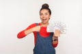 Wow, look at money, big profit! Portrait of shocked lottery winner, surprised rich girl with hair bun in denim overalls Royalty Free Stock Photo