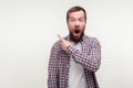 Wow, look there! Portrait of shocked bearded man pointing finger to the side up, empty space. isolated on white background