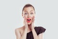 Wow, OMG. Shocked surprised stunned. Closeup portrait happy young woman looking excited in full disbelief hands on cheeks isolated