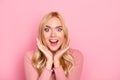 Wow, sale. Close up portrait of young pretty woman with long blond hair looking exited holding her mouth open, hands near cheeks,