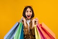 Wow seasonal sales concept. Overjoyed woman holding lot of bright shopping bags, posing over yellow background