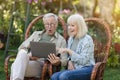 Wow. Senior married couple looking at laptop, surprised by good unbelievable news, surfing internet, resting in garden Royalty Free Stock Photo