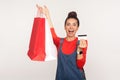 Wow, shopping loan! Portrait of surprised stylish girl holding packages with credit card and shouting in amazement Royalty Free Stock Photo