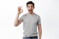 Wow super good. Happy guy showing okay sign and look amazed, checking out something awesome cool, praise excellent thing Royalty Free Stock Photo