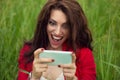 Wow, surprise good news by phone. Happy woman looking at mobile phone texting surprising message, photos in social media. Positive Royalty Free Stock Photo