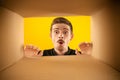 Wow. Surprised man unpacking, opening carton box and looking inside with wide open eyes. Delivery, surprise, gift, wow Royalty Free Stock Photo