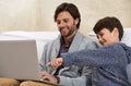 Wow Thats awesome. A young boy and his father playing on a laptop.