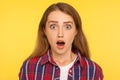 Wow, unbelievable! Portrait of shocked surprised ginger girl in checkered shirt looking at camera with open mouth and amazed big