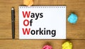 WOW ways of working symbol. Concept words WOW ways of working on white note on a beautiful wooden background. Metallic pen.