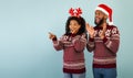 Wow xmas offer. Surprised black couple pointing and looking at empty space on blue background, panorama with copy space