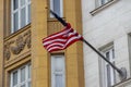 Waving wrapped around flagpole flag of the US, moscow building in stalin empire style