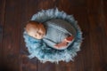 Wrapped in blue fabric, a newborn sleeping baby lies in a basket on blue fur Royalty Free Stock Photo