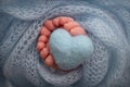 Wrapped in a blue knitted blanket, wrapped. Knitted heart in baby& x27;s newborn legs Royalty Free Stock Photo