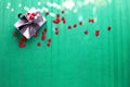 Wrapped box with present and many red little hearts  on  green textured  paper background. Royalty Free Stock Photo