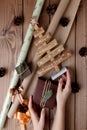 Wrapped Christmas gifts in craft paper on wooden table. Process of wrapping gifts. Lifestyle background. View from above. Royalty Free Stock Photo