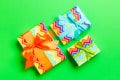 Wrapped Christmas or other holiday handmade present in paper with blue, green and orange ribbon on green background. Present box, Royalty Free Stock Photo